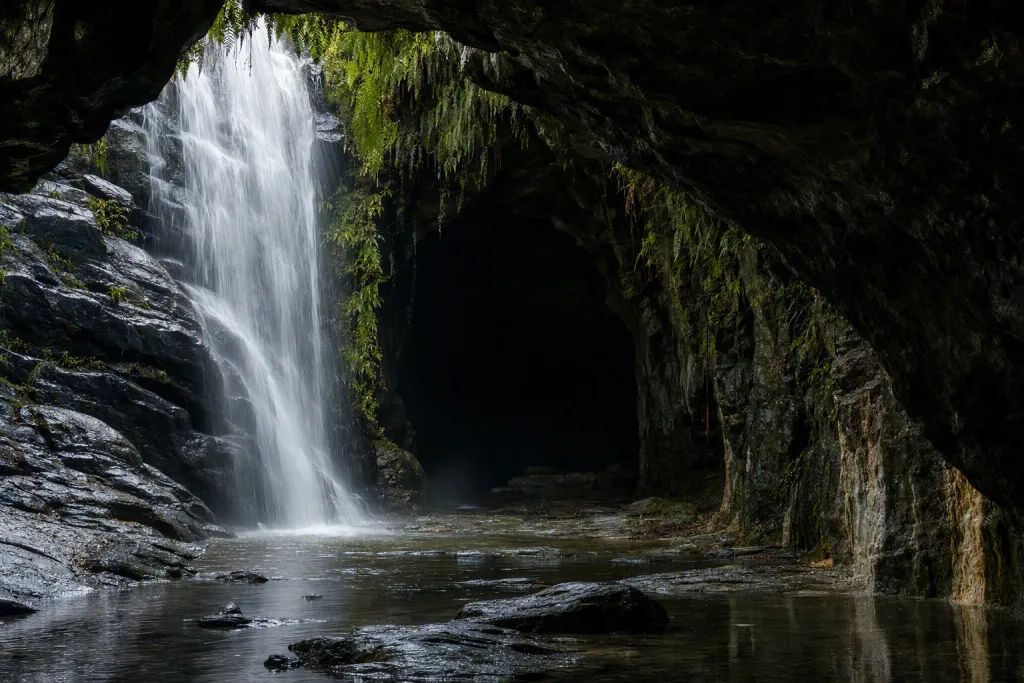 Scène naturelle d’entrée de grotte en cascade, crique cachée